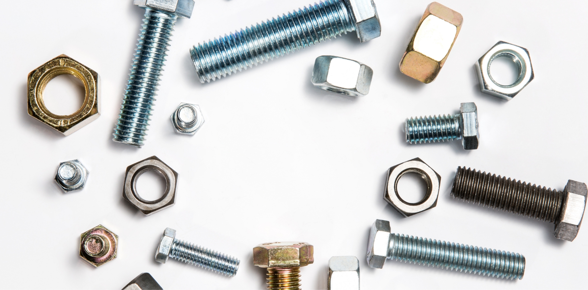 A Bunch Of Nuts And Bolts On A White Surface