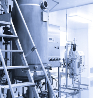 a blue and white photo of a factory with stairs leading up to a large tank .