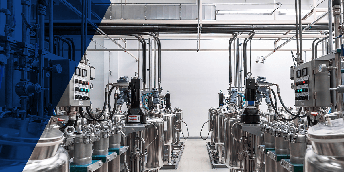 a row of stainless steel tanks are lined up in a chemical processing factory