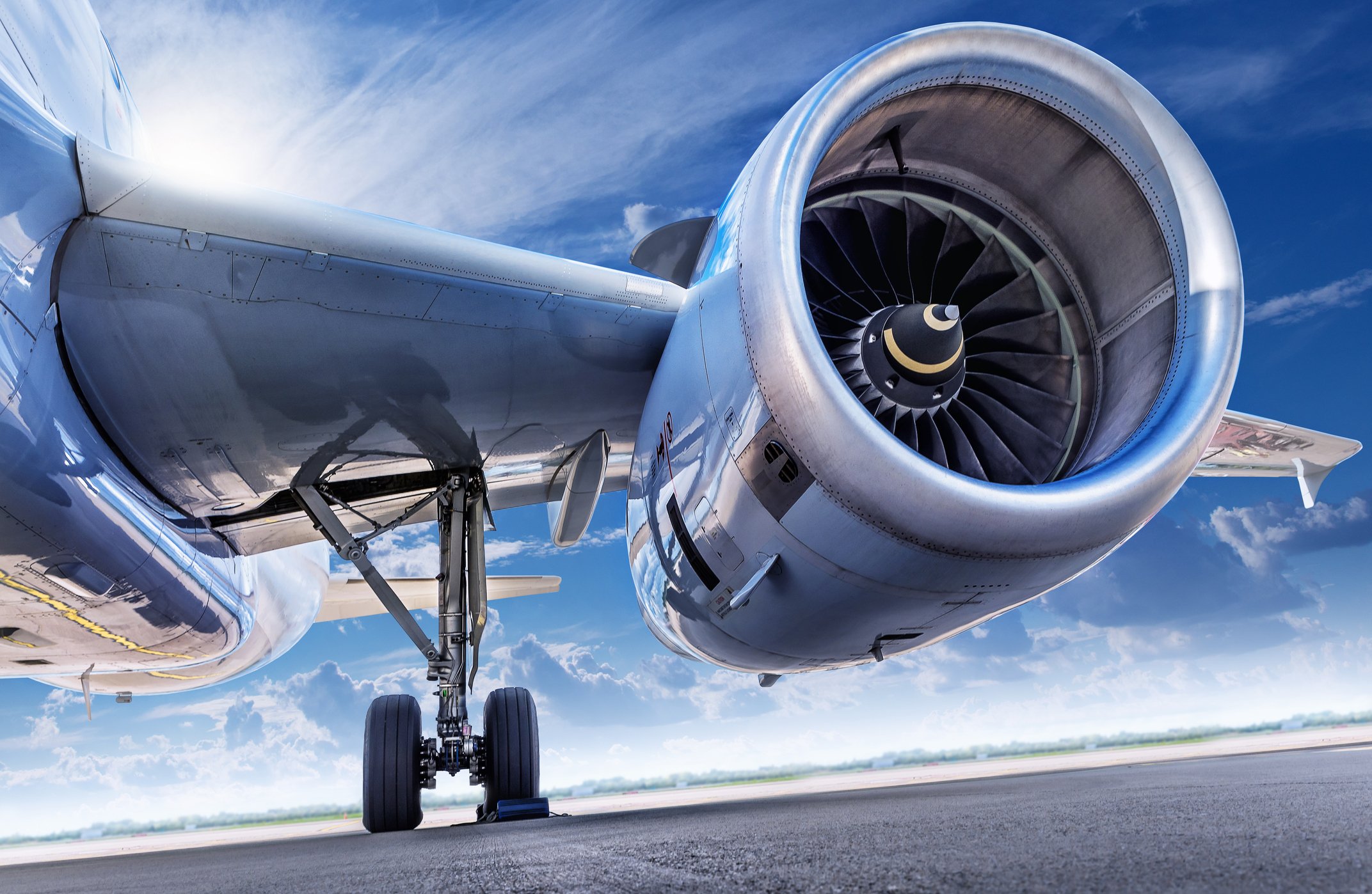 A Close Up Of A Plane's Engine With A Blue Sky In The Background