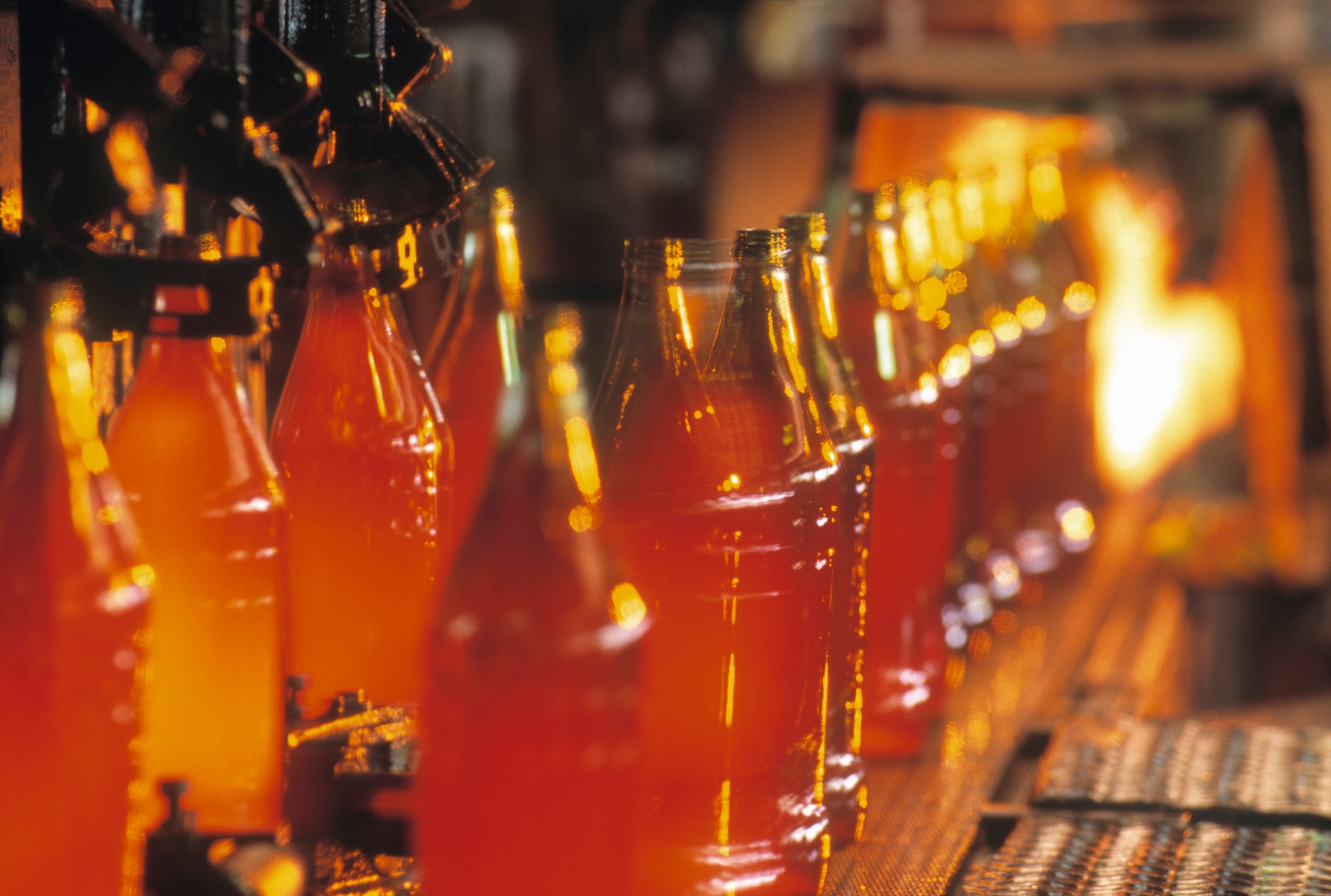 A Row Of Glass Bottles Are Being Made In A Factory