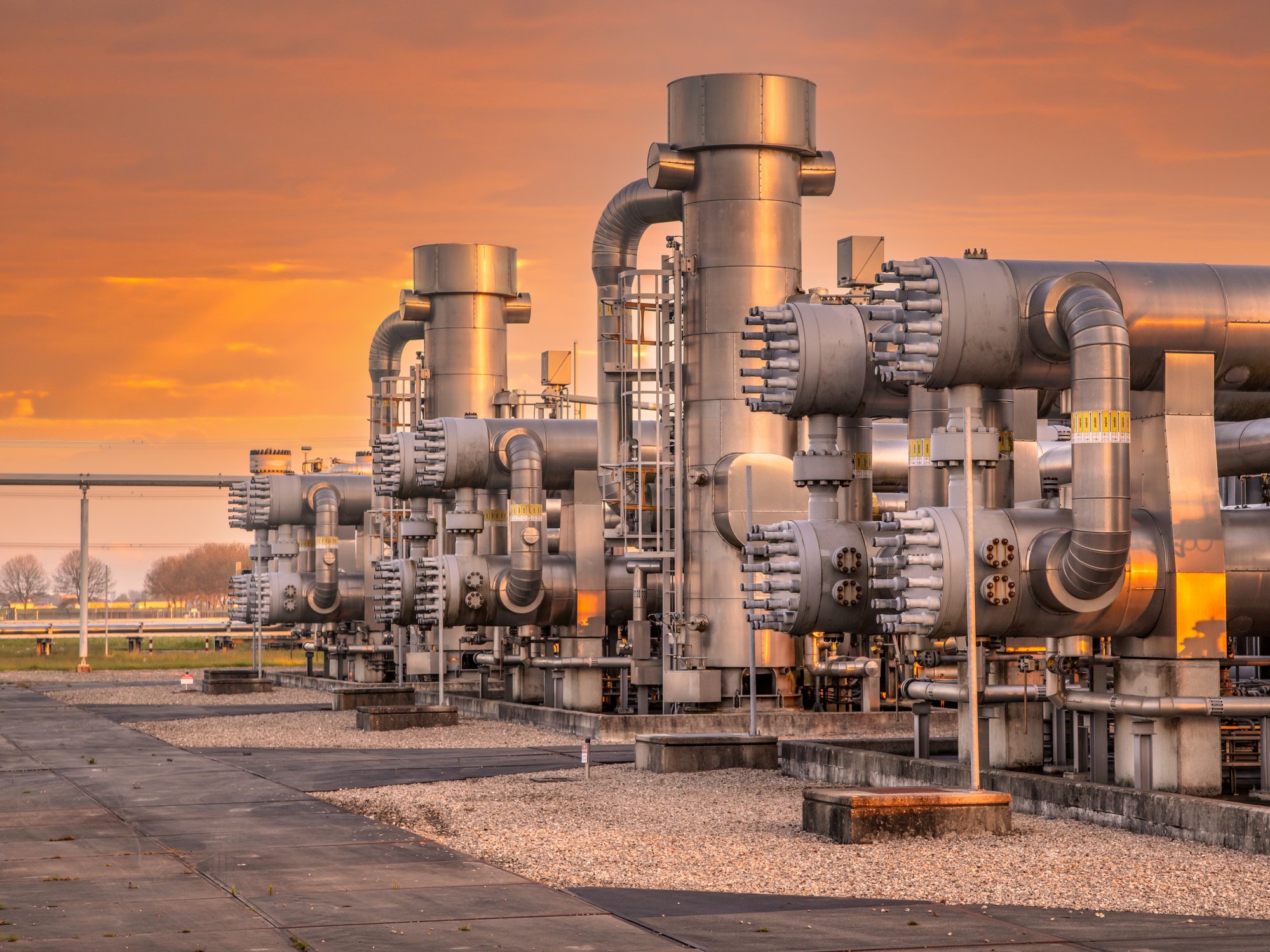 A Row Of Large Pipes With A Sunset Background