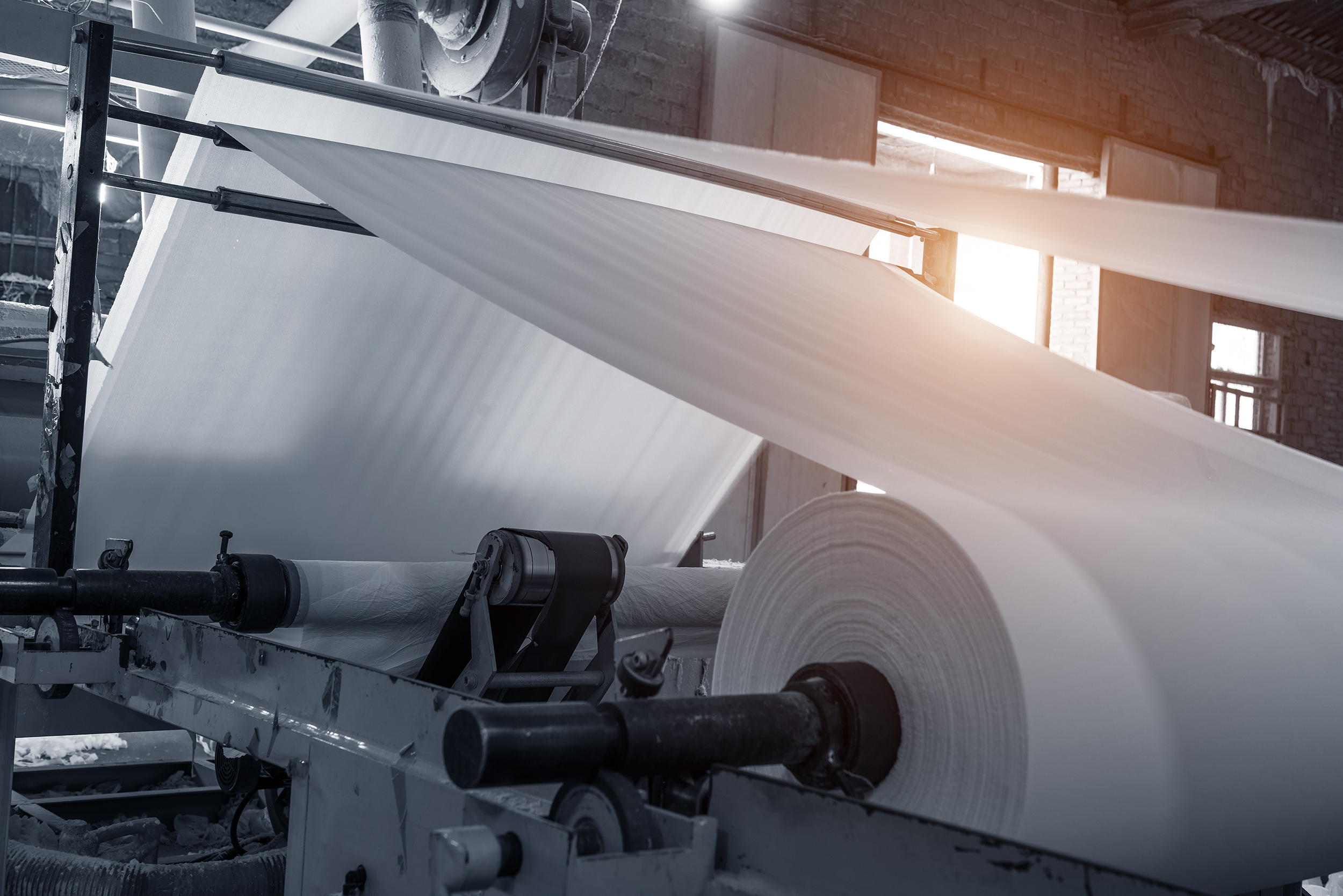 Large Rolls Of Paper Are Being Rolled In A Factory