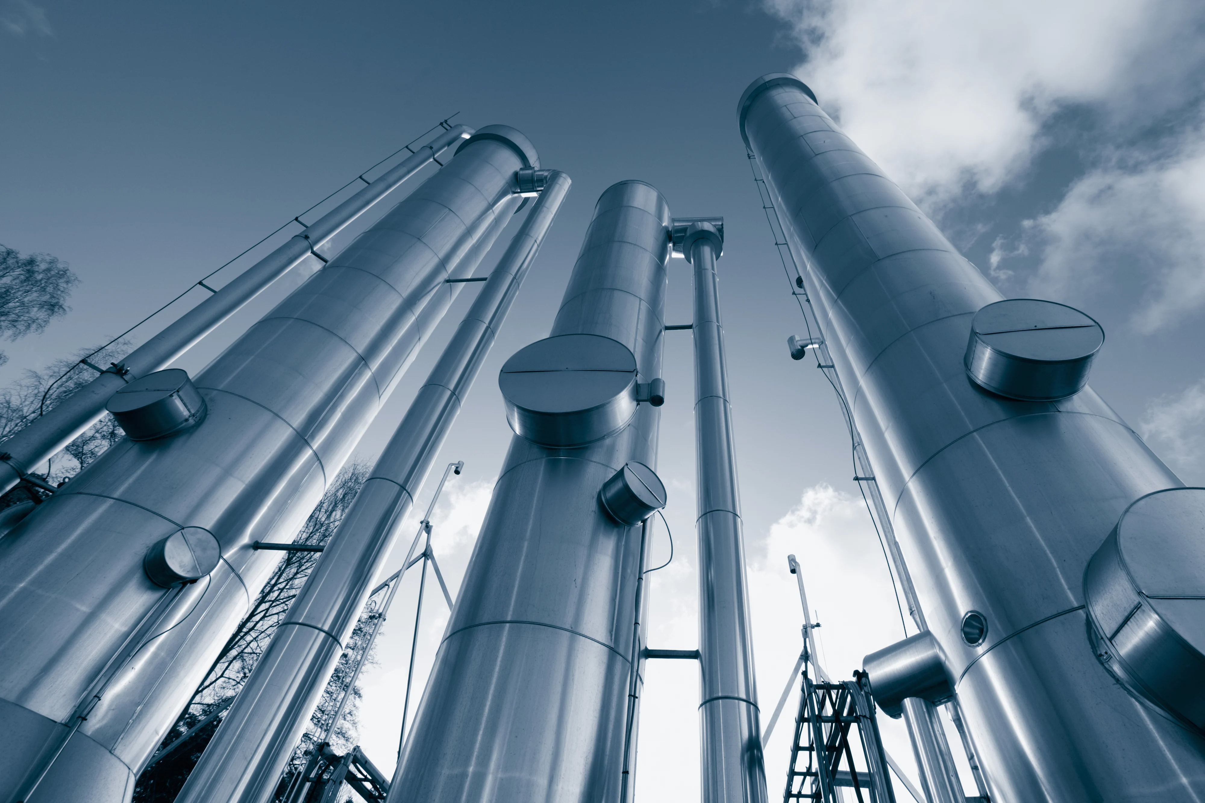 a row of oil and gas pipelines against a blue sky